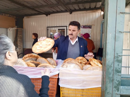 ELİYLE EKMEK DAĞITAN  MUHTAR.